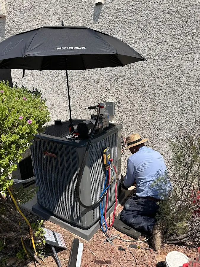 HVAC technician performing outdoor AC maintenance in Pelham